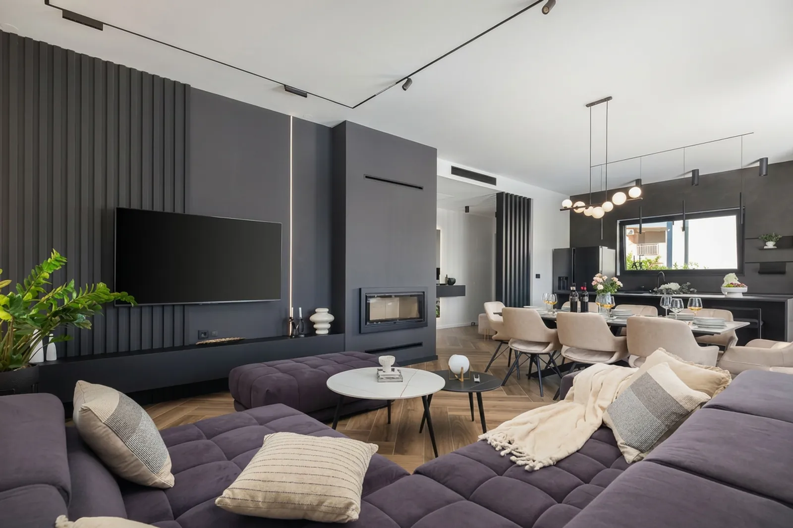 Living area with media wall flowing into the dining space