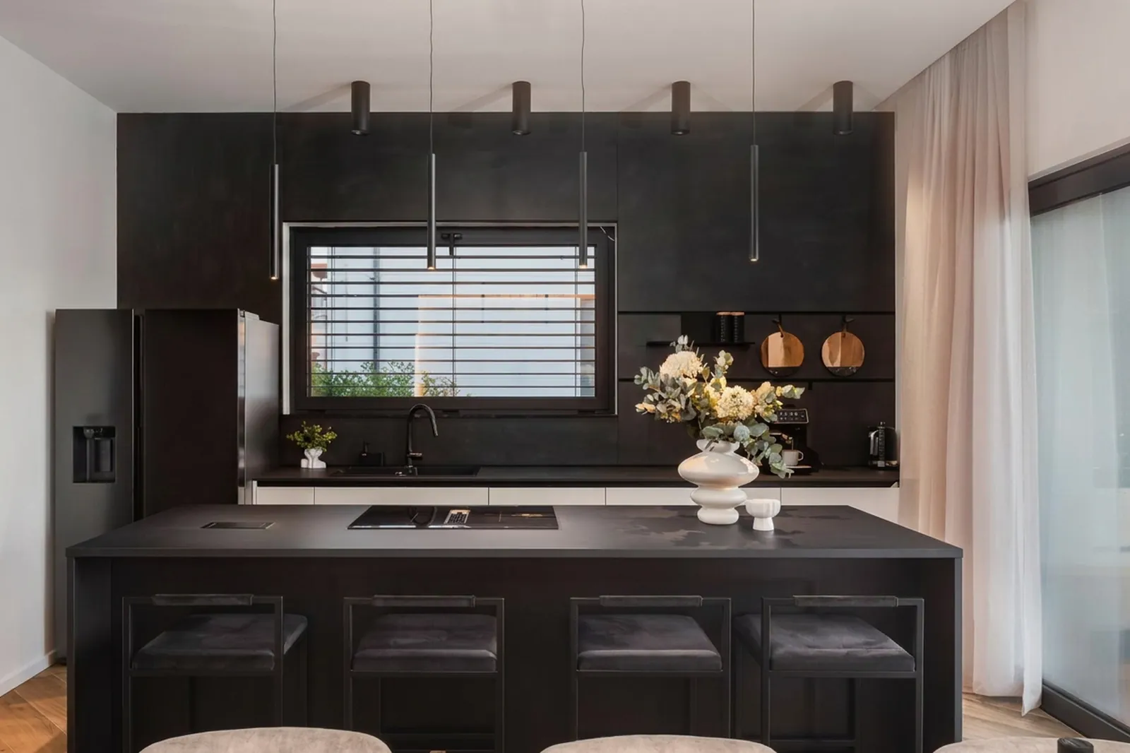 Dark kitchen island with bar seating and styled shelves