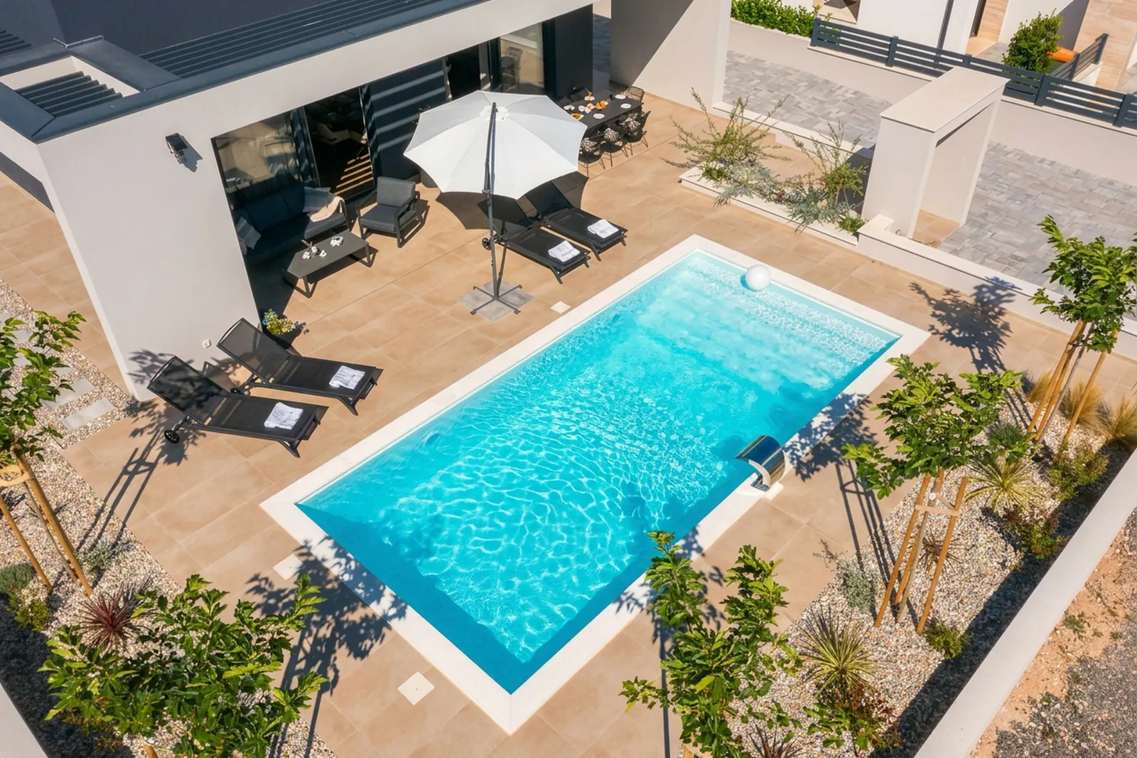 Aerial view of Villa M's fenced pool, sun deck and garden