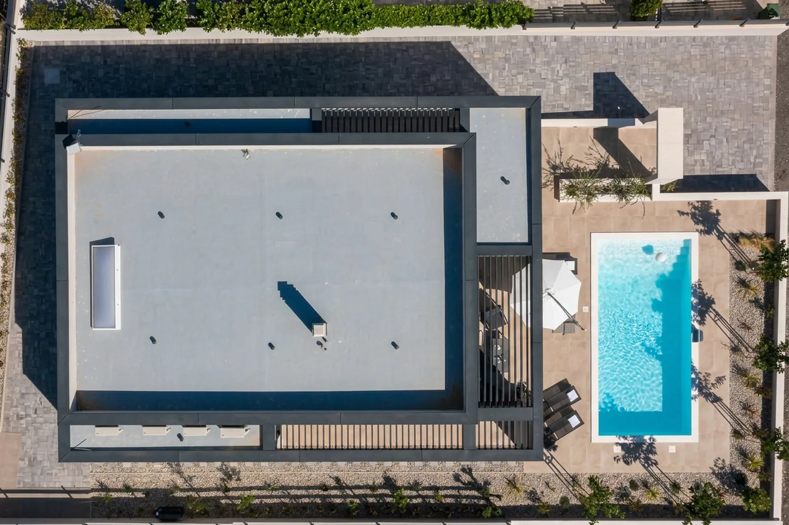 Top-down aerial of Villa M showing the roofline, pool and plot