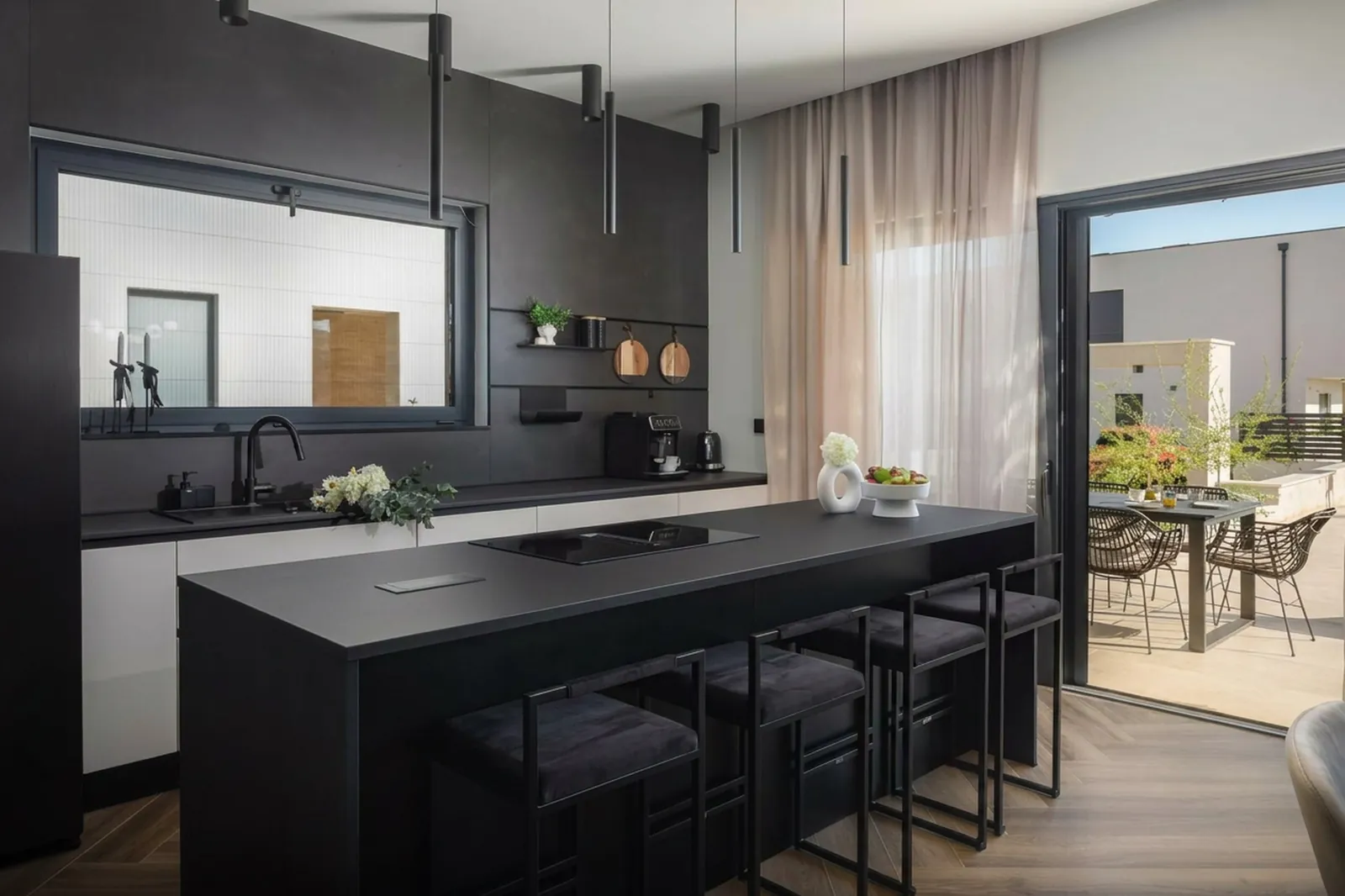 Kitchen island with induction hob open to the terrace view