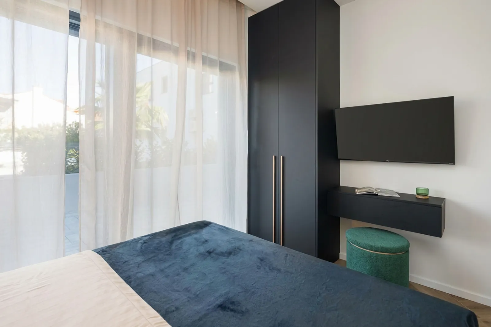 Bedroom with a deep blue throw and layered lighting