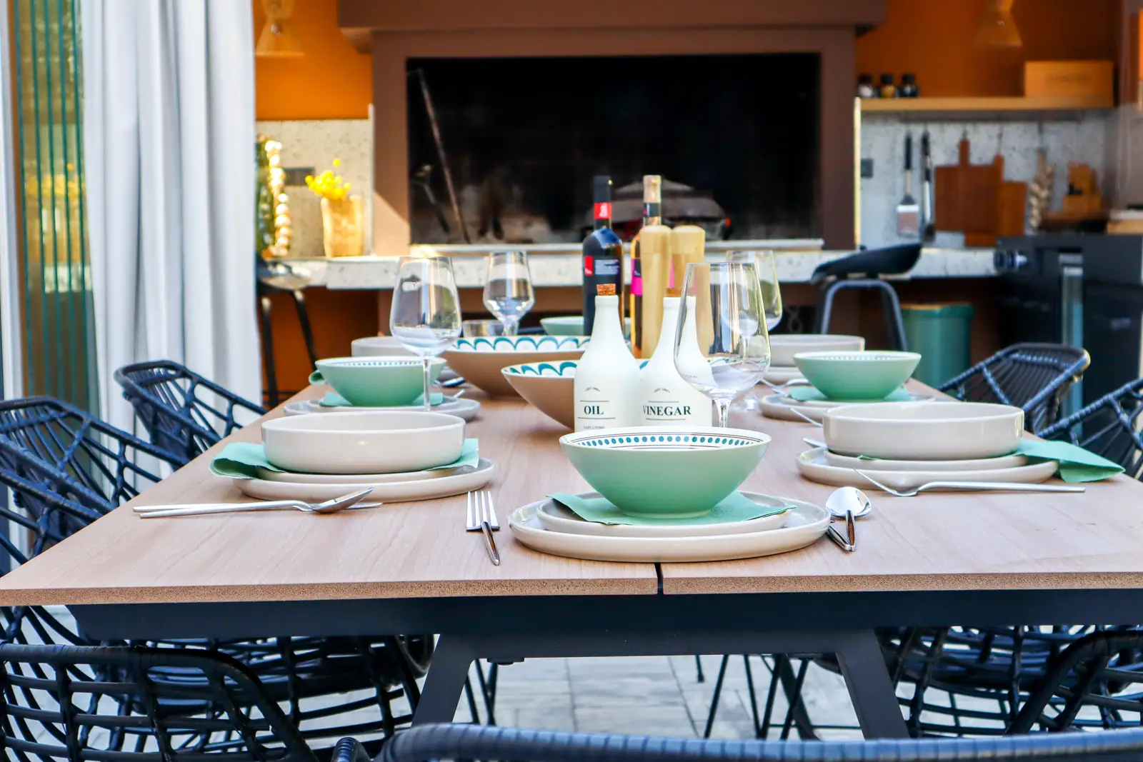 Outdoor dining table behind the house beside the summer kitchen and grill