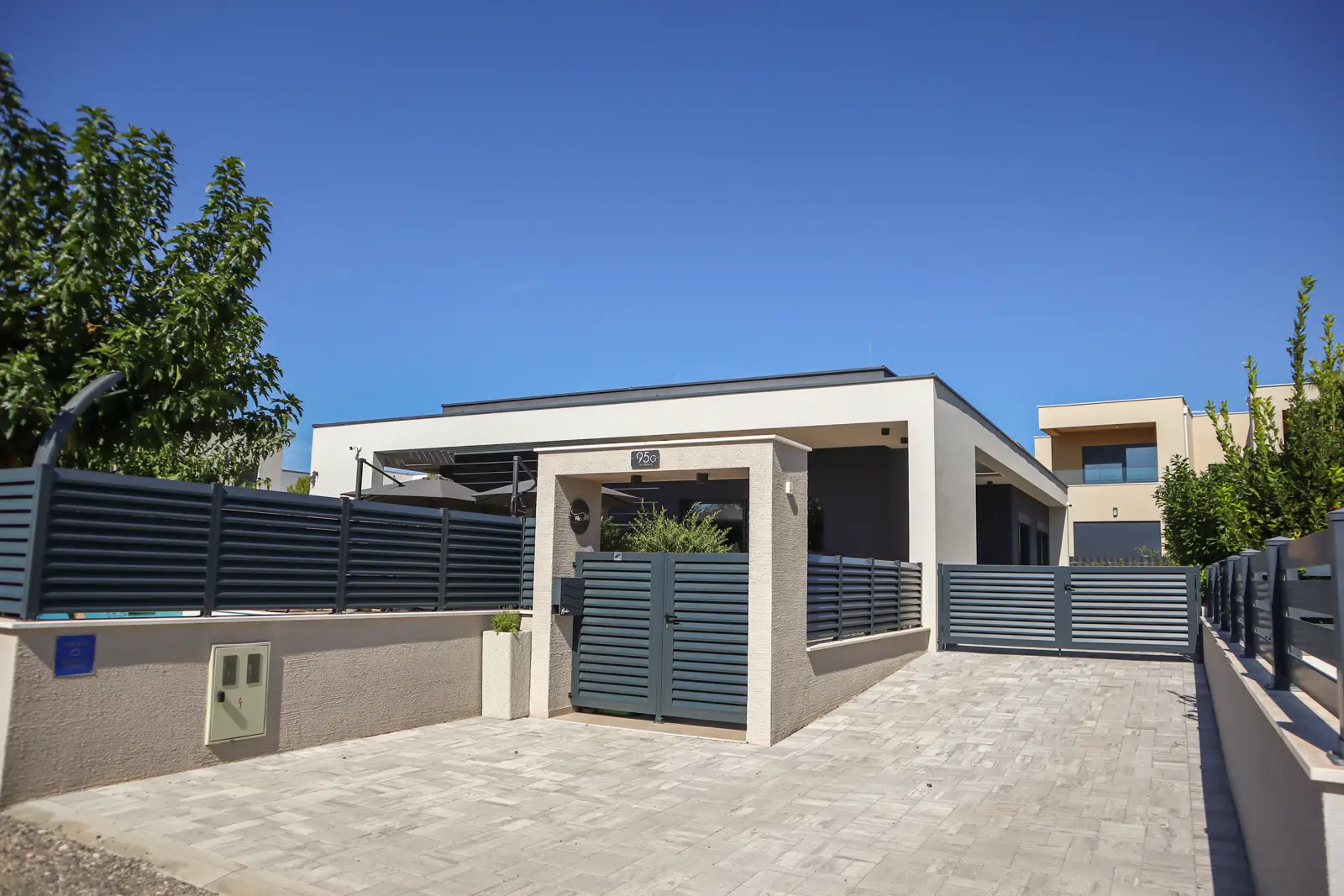 Villa M from the street showing the people door and car parking door